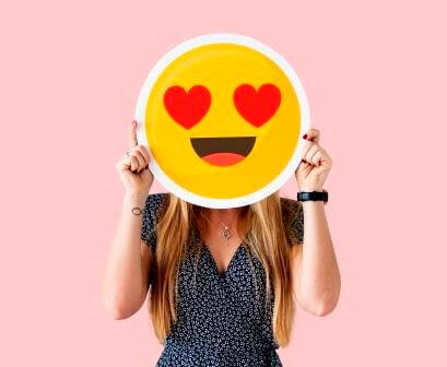 Cheerful woman holding emoticon icon how to calm down when angry 5