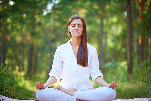 a woman practicing meditation in the forest for diabetes prevention and more