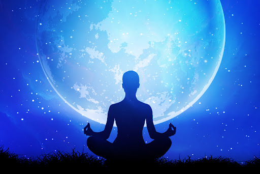 a woman in a meditating pose under moonlight