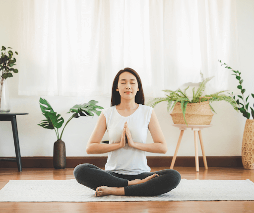 A girl meditating at home for back pain relief.