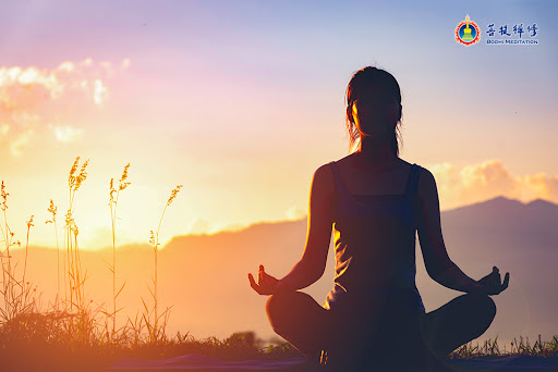 A woman meditating in the Buddhist way under the sun.