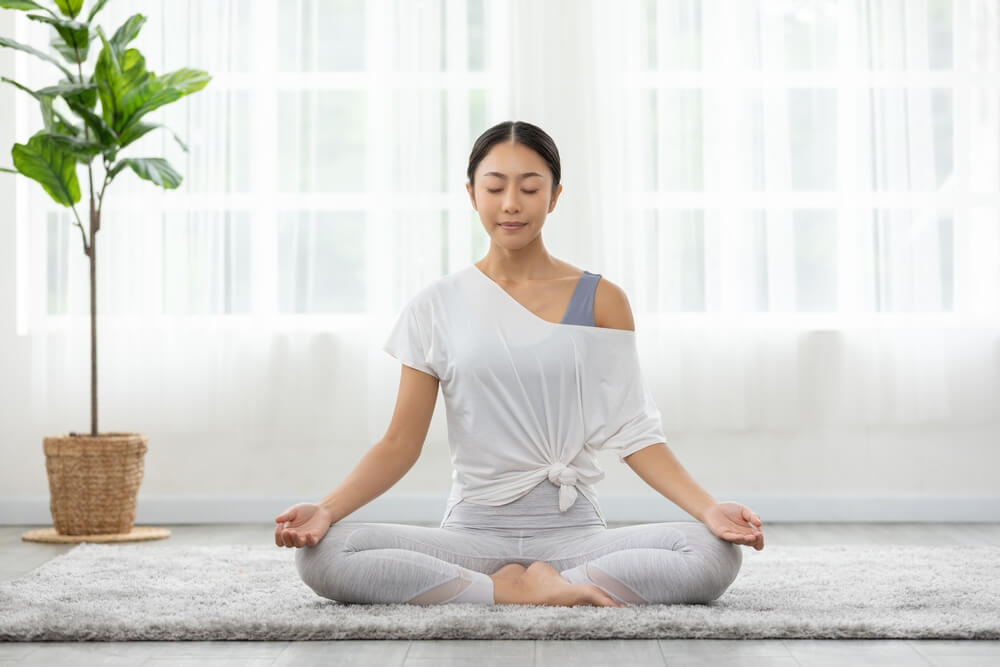 A young woman meditating for weight loss and fitness.