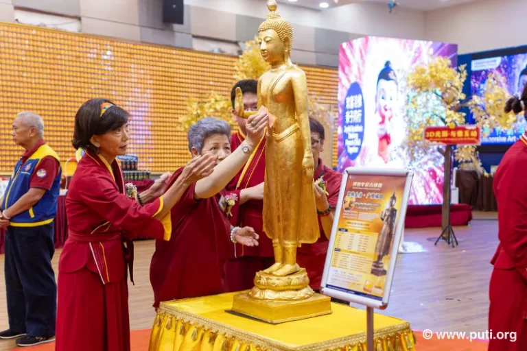 Volunteers assisting participants in gilding the Buddha statue