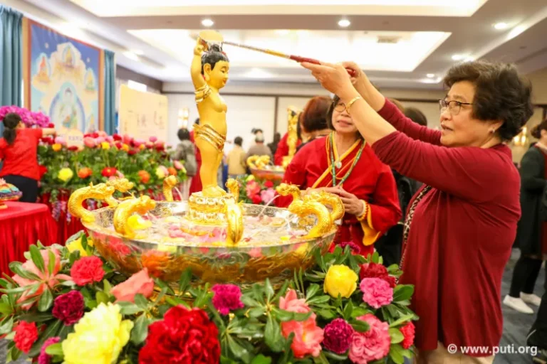 Families participate in bathing the Buddha activity together, smiling with sincerity and devotion