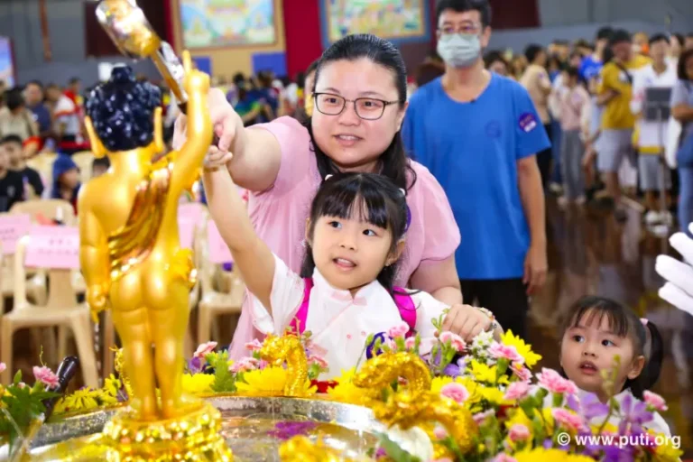 Families participate in bathing the Buddha activity together, smiling with sincerity and devotion