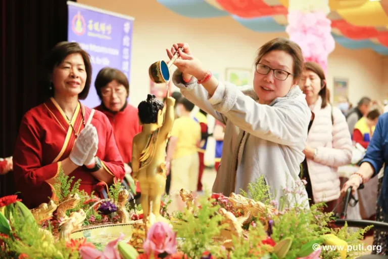 Families participate in bathing the Buddha activity together, smiling with sincerity and devotion
