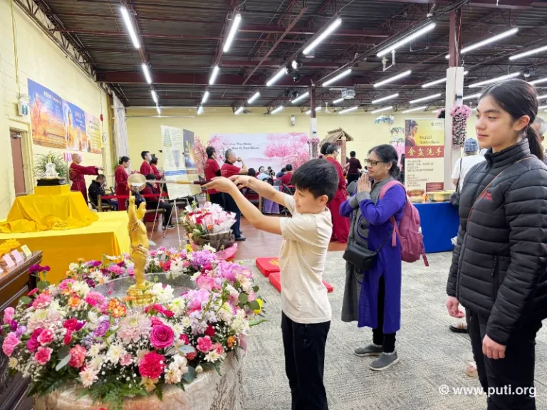 Families participate in bathing the Buddha activity together, smiling with sincerity and devotion