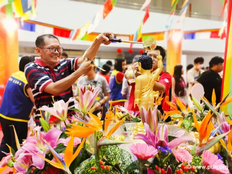Families participate in bathing the Buddha activity together, smiling with sincerity and devotion