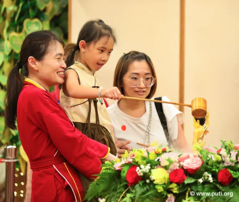 Families participate in bathing the Buddha activity together, smiling with sincerity and devotion